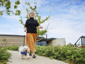 Lifestyle Communities® Mount duneed Lady walking dog outside clubhouse low res