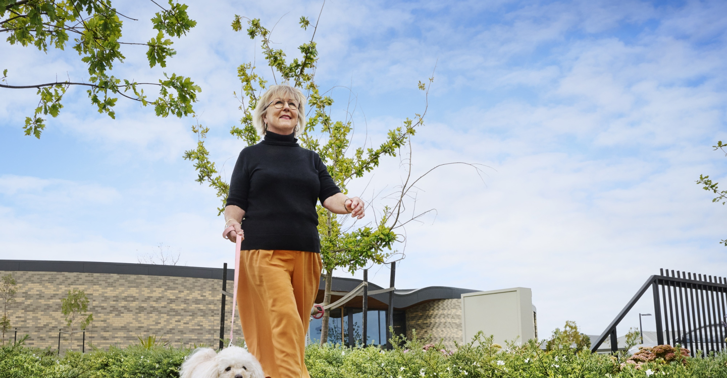 Lifestyle Communities® Mount duneed Lady walking dog outside clubhouse