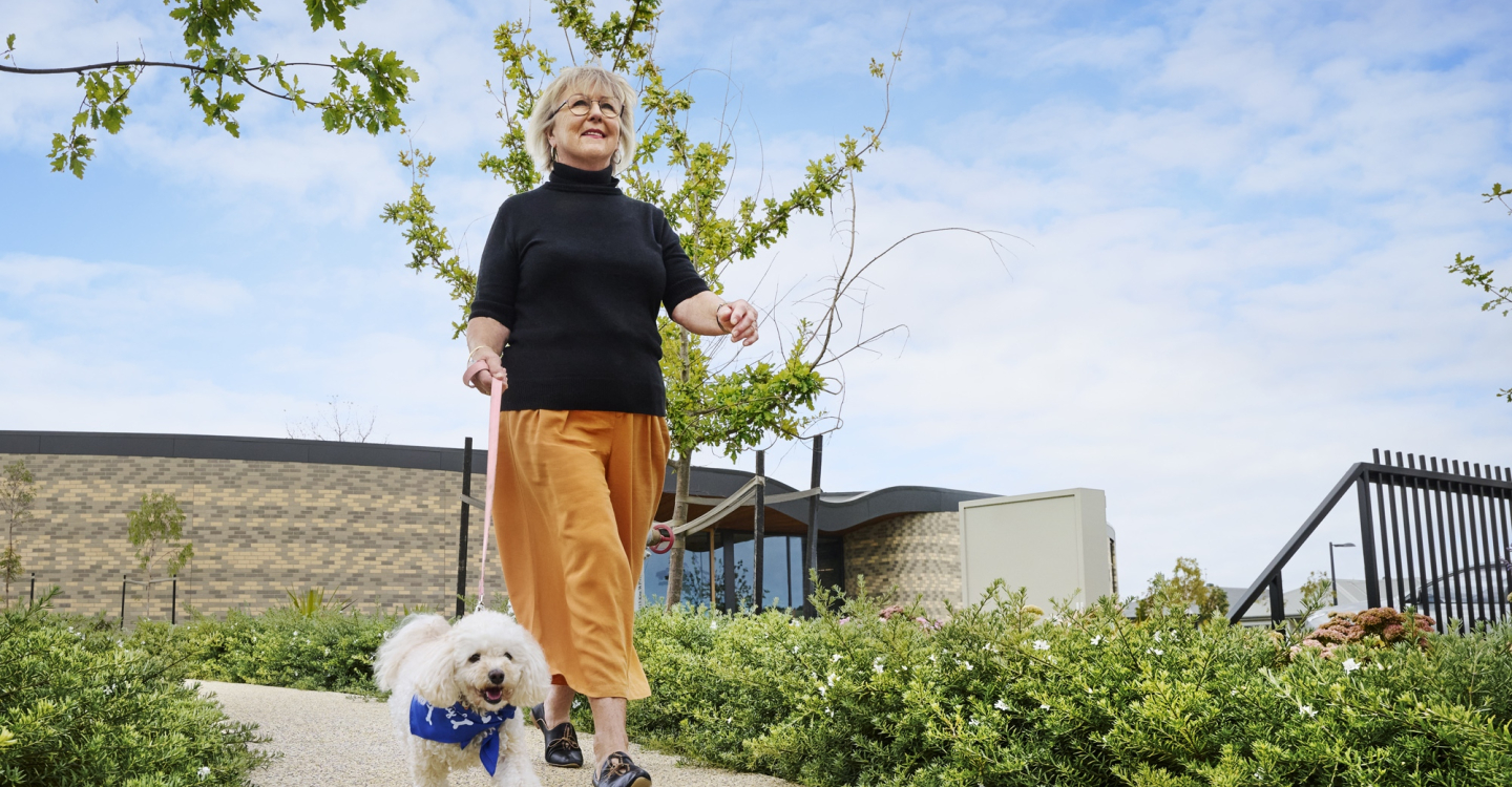 Lady walking dog Pets outside clubhouse